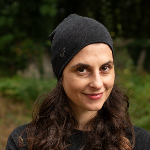 Wanderer trägt Merinowolle Beanie in der Farbe Anthrazit im Wald.