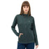 Dame mit langen braunen Haaren trägt eine grüne Jacke aus Merinowolle.