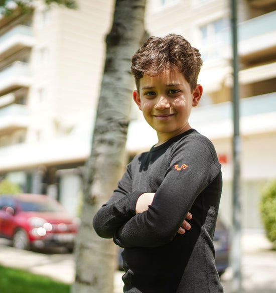 Junge in einem schwarzen Merino-Baselayer