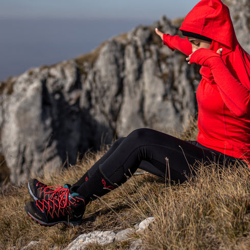 Dame mit rotem Merino-Hoodie und Wandersocken aus Merinowolle