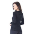 Eine Frau richtet ihren Blick nach Hinten und trägt ein schwarzes Langarmshirt aus Merino